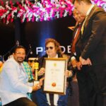 Dr. Manu Menon receiving National Excellency Award from Legendary Music Director Mr. Bappi Lahiri.